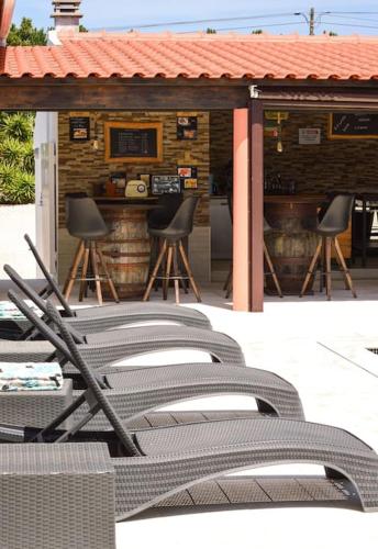 a group of chairs sitting in front of a bar at La Casa De Lylou location de bungalows in Lavos