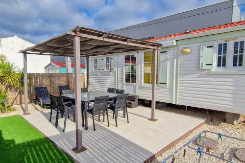 a patio with a table and chairs and a house at La Casa De Lylou location de bungalows in Lavos