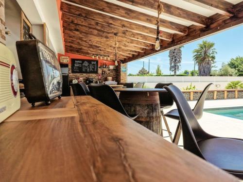 a restaurant with a table and chairs and a pool at La Casa De Lylou location de bungalows in Lavos