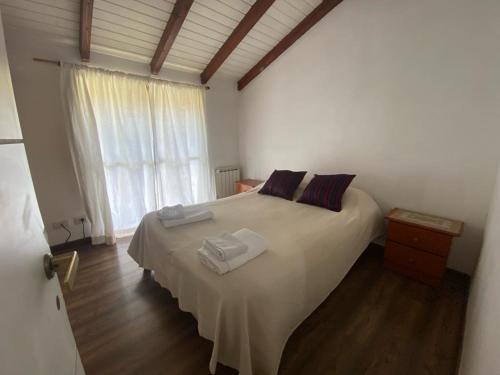 a bedroom with a bed with two towels on it at Ohana in San Carlos de Bariloche