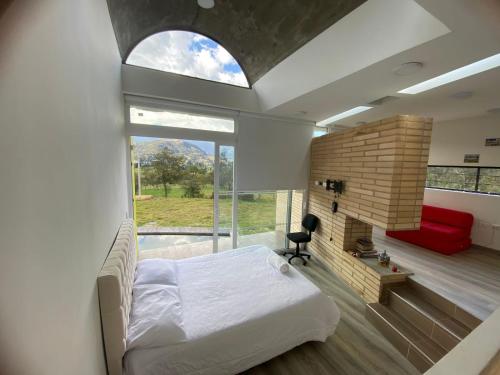 ein Schlafzimmer mit einem Bett und einem großen Fenster in der Unterkunft Chalet Cerinza by Malaver in Cerinza