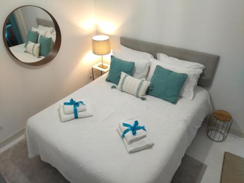 - une chambre avec un lit doté d'oreillers blancs et bleus dans l'établissement Cais das Pedras Pátio Apartment, à Porto