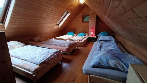 um quarto com 3 camas num chalé de madeira em Chata Sport Vysočina em Nové Město na Moravě