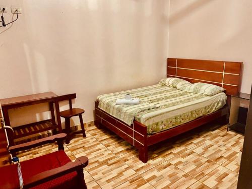 a bedroom with a bed and a desk and a table at Hotel Juan Diego Pucallpa in Pucallpa