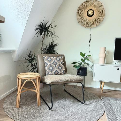 een stoel en een tafel in een kamer met planten bij Hotspot 83 in Alkmaar
