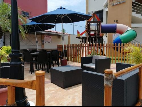 an outdoor patio with a playground with an umbrella at MarySol Las Palmas in Rincon de Guayabitos