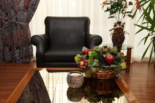 a living room with a chair and a table with a basket of vegetables at Anemoni Piraeus Hotel in Piraeus