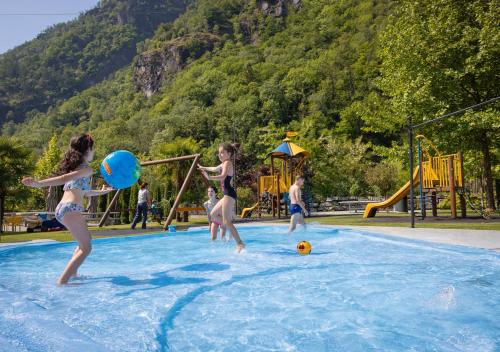 un grupo de niños jugando en una piscina en Camping Piccolo Paradiso, en Avegno