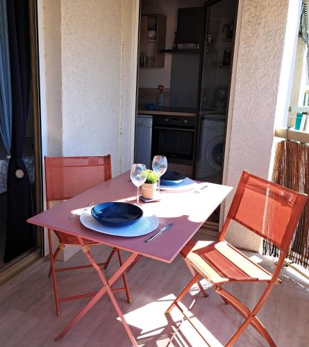 une table violette avec deux assiettes et des verres à vin dans l'établissement Le Palais Royal, à Saint-Raphaël