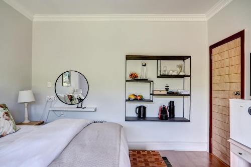 a bedroom with a bed and a mirror at Beautiful Abalone in Hermanus