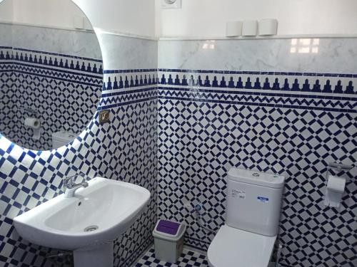 łazienka z umywalką, toaletą i lustrem w obiekcie Duplex 1 pour les familles w mieście Oualidia