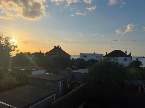 a sunset over a city with houses and roofs at Broadway Beach Home with Hot tub in Herne Bay