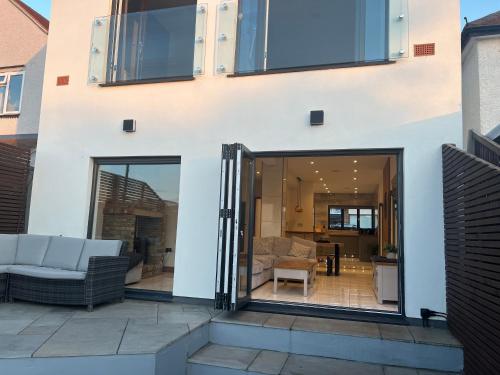 a house with sliding glass doors leading into a living room at Broadway Beach Home with Hot tub in Herne Bay