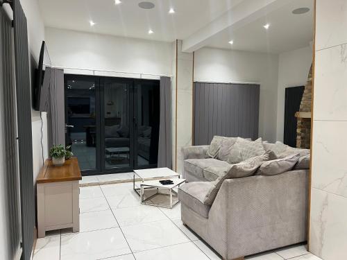 a living room with a couch and a table at Broadway Beach Home with Hot tub in Herne Bay