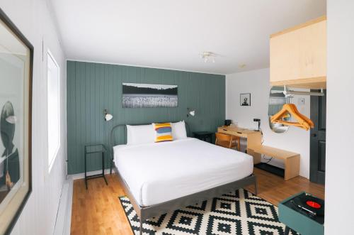 a bedroom with a bed with a green wall at Beatnik Hotel in Bromont