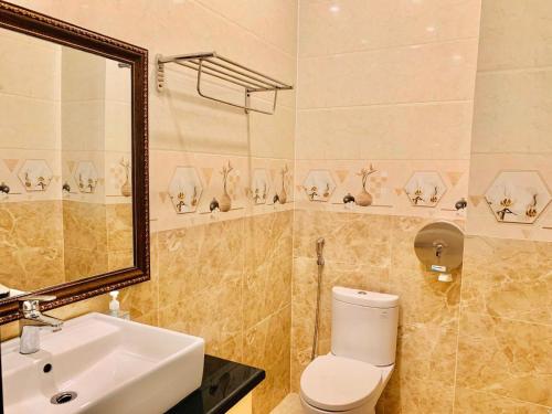 uma casa de banho com um WC, um lavatório e um espelho. em Ngọc Mai Hotel em Rạch Giá