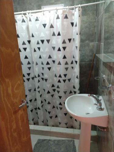 a bathroom with a sink and a shower curtain at Relax Serrano in Santa María