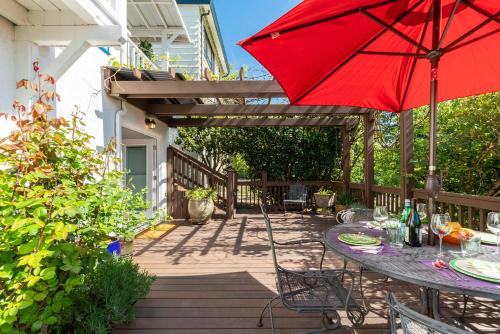 a table with a red umbrella on a patio at Laurelhurst - Cozy 1 Bedroom Apt Near Children’s Hospital and UW in Seattle