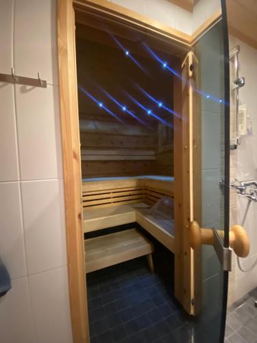 an empty cabinet in a bathroom with blue lights at Hirsihuvila Kolilla, Villa Lumme in Hattusaari