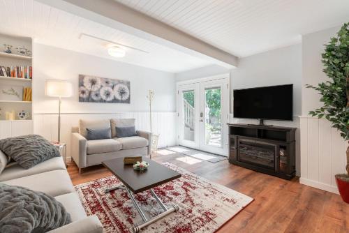 a living room with a couch and a tv at Laurelhurst - Cozy 1 Bedroom Apt Near Children’s Hospital and UW in Seattle