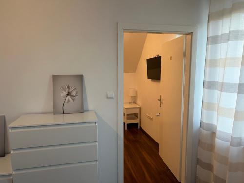 a bedroom with a dresser and a door to a hallway at Tara's apartment in Vrhnika