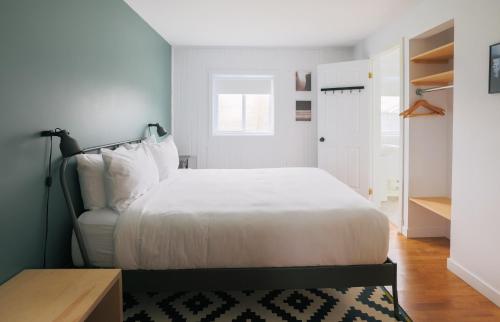 a bedroom with a white bed and a desk at Beatnik Hotel in Bromont