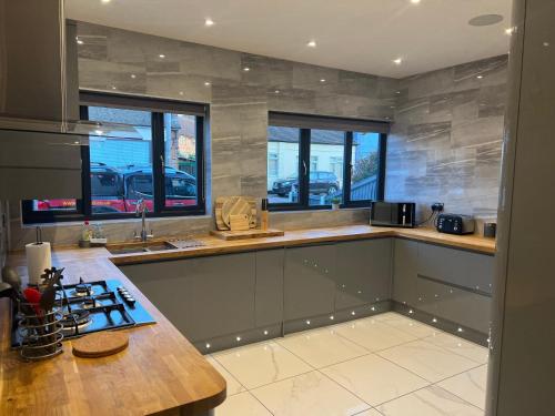 a kitchen with a counter top and some windows at Broadway Beach Home with Hot tub in Herne Bay