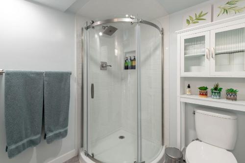La salle de bains blanche est pourvue d'une douche et de toilettes. dans l'établissement Laurelhurst - Cozy 1 Bedroom Apt Near Children’s Hospital and UW, à Seattle