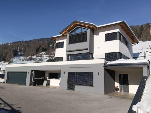 uma casa branca com muitas janelas em Sonnen-Appartement Heidi em Sankt Michael im Lungau