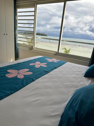 a bedroom with a bed with a view of the beach at Pension Irivai, appartement UO UO 3 chambres vue mer in Uturoa