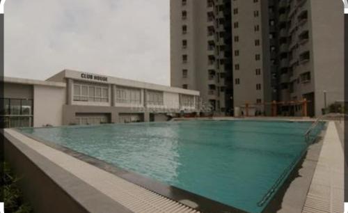 una grande piscina di fronte a un edificio di Luxury retreat with golf view a Hinjewadi