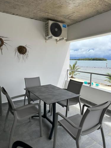 a table and chairs on a balcony with a view of the ocean at Pension Irivai, appartement UO UO 3 chambres vue mer in Uturoa