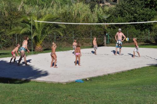 a group of people playing volleyball on a beach at Casa Campanella Resort in Capoliveri