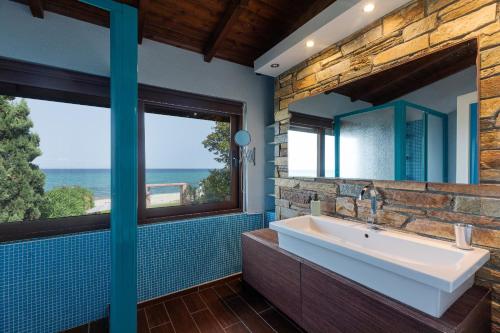 a bathroom with a large sink and a large window at Efharis Beachfront Villa in Platamonas