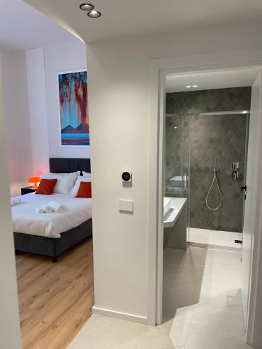 a bedroom with a bed and a bathroom with a shower at Rolando Domus in Naples