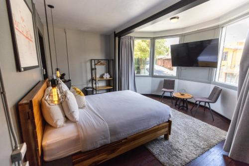 una camera con un grande letto e una TV di Selina San Jose a San José