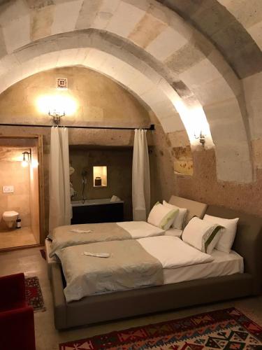 a bedroom with a large bed in a stone room at Pigeon Hotel Cappadocia in Uchisar