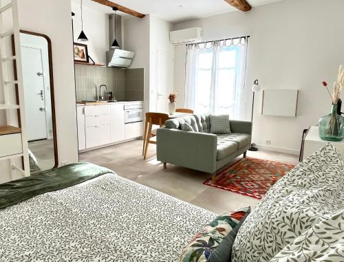 Cet appartement comprend une chambre avec un lit et un canapé ainsi qu'une cuisine. dans l'établissement La maison du douanier. Un balcon au soleil, à Antibes