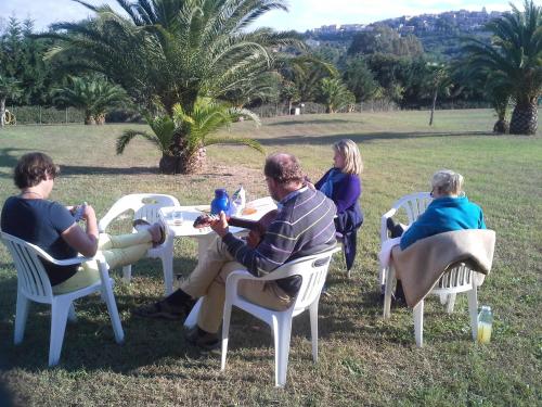 a group of people sitting around a table in a field at Casa Campanella Resort in Capoliveri