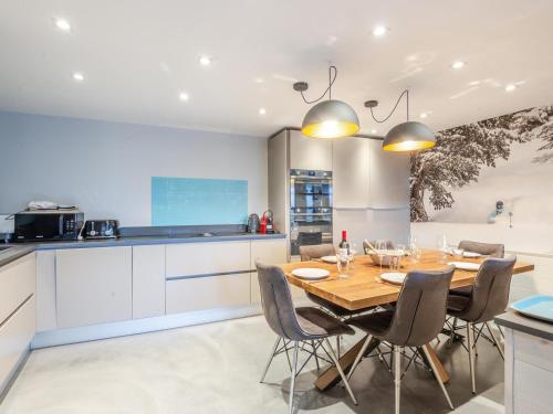 une cuisine et une salle à manger avec une table et des chaises en bois dans l'établissement Joli 3 pièces rénové en centre-ville de Morzine avec balcon et parking - FR-1-754-21, à Morzine