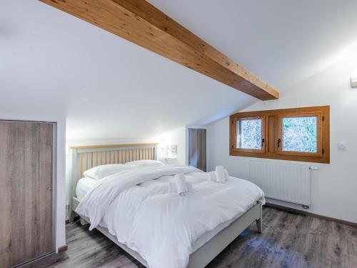 une chambre avec un grand lit avec des draps blancs dans l'établissement Appartement neuf 4 chambres au pied des pistes avec terrasse, parking et services inclus - Morzine - FR-1-754-14, à Morzine