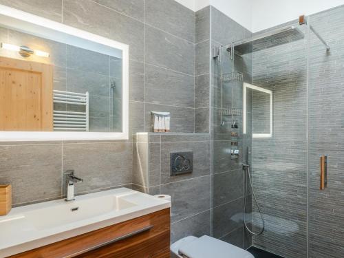une salle de bain avec un lavabo et une douche en verre dans l'établissement Appartement neuf 4 chambres au pied des pistes avec terrasse, parking et services inclus - Morzine - FR-1-754-14, à Morzine