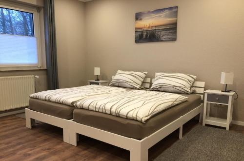1 dormitorio con 1 cama grande y 2 mesitas de noche en Ferienwohnung Zum Dütetal OG Apartment 1 en Hilter am Teutoburger Wald