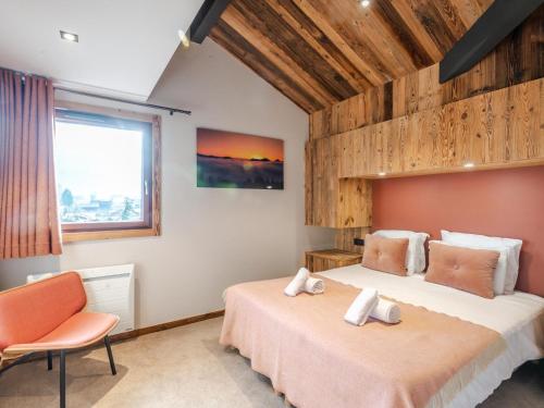 une chambre avec deux lits et une chaise et une fenêtre dans l'établissement Duplex rénové au centre avec garage double et wifi - FR-1-754-11, à Morzine