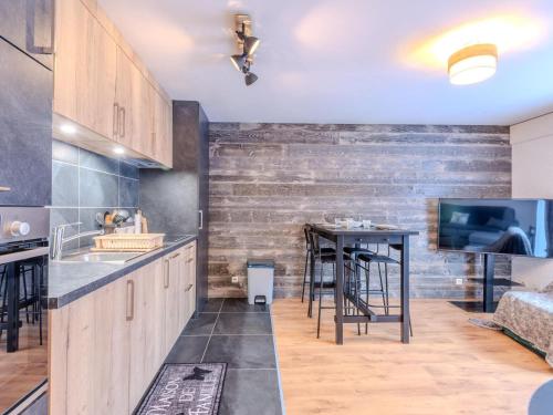 une cuisine avec des placards en bois et un bar avec une table dans l'établissement Studio-cabine rénové en centre, 200m des pistes, pour 4 personnes - Morzine - FR-1-754-49, à Morzine