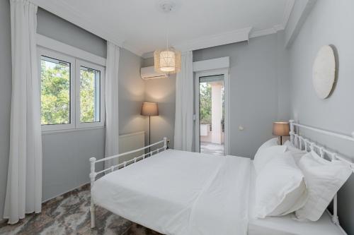 プラタモナスにあるVilla IOの白いベッドルーム(ベッド1台、ソファ付)