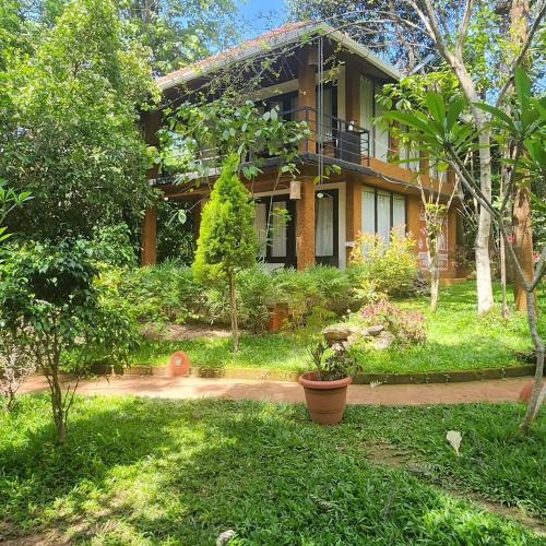 a house with a garden in front of it at Le Kuruva isles wayanad jungle resort in Chekadi