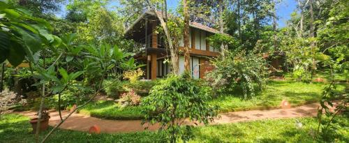 a house in the middle of a garden at Le Kuruva isles wayanad jungle resort in Chekadi