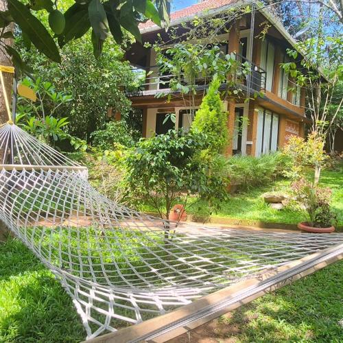 eine Hängematte im Hof eines Hauses in der Unterkunft Le Kuruva isles wayanad jungle resort in Chegāt