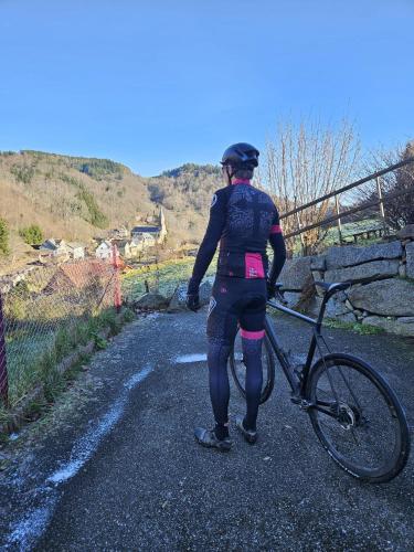 a woman standing next to a bike on a gravel road at Vacances au Bonhomme in Le Bonhomme